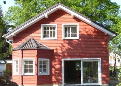 Einfamilienhaus mit Erker und roter Stülpschalung