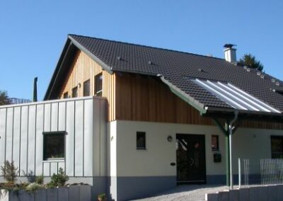 Zweifamilienhaus mit vergrauter Lärchenschalung und grünen Fenstern / Foto: Tanja Hauptstock
